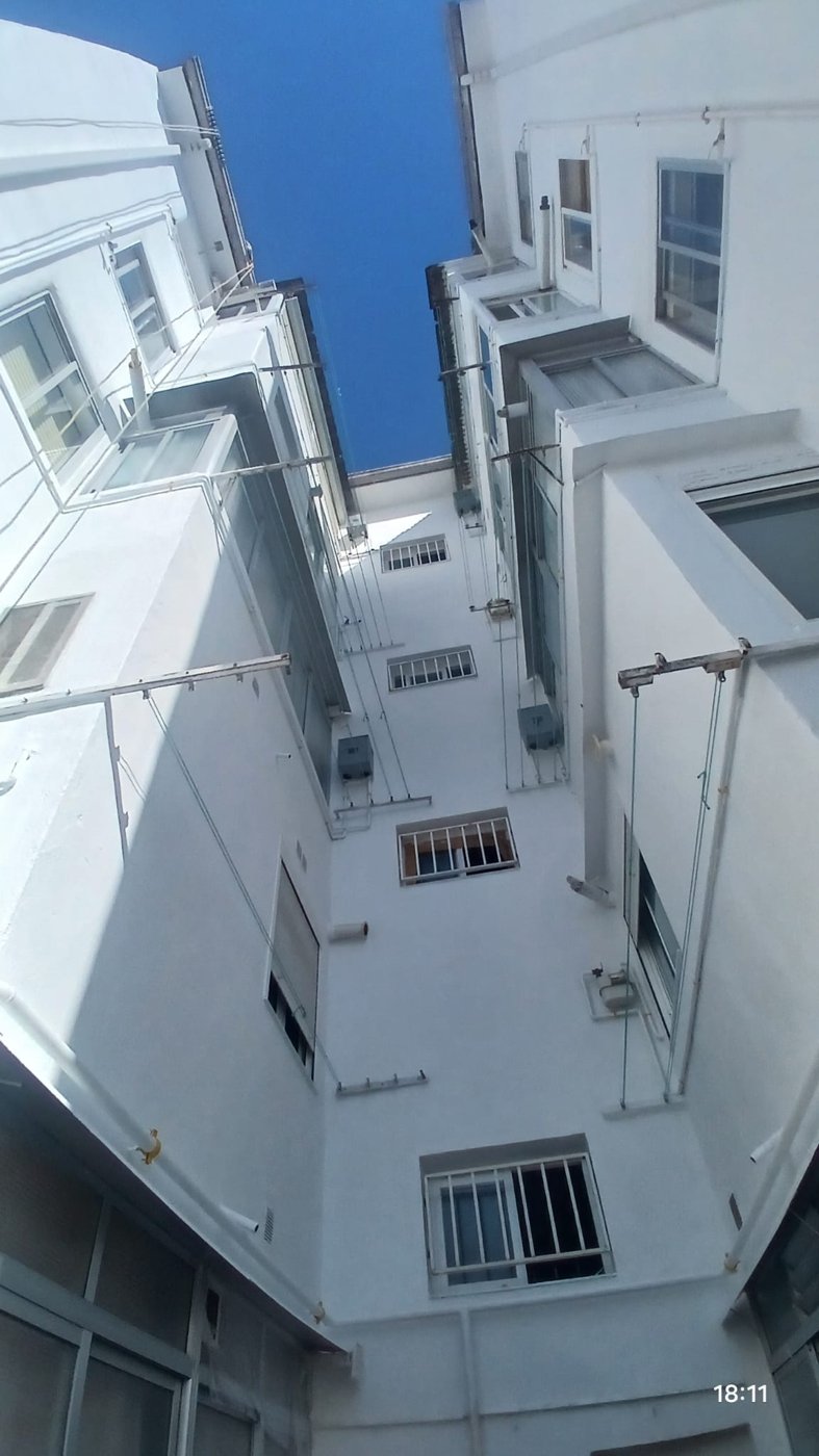 Vista de un patio interior con fachadas blancas rehabilitadas